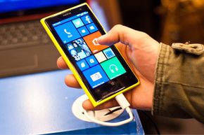 一名男子在2013年10月的伦敦应用世界展览会上检查了运行Windows Phone 8并拥有4100万像素摄像头的新诺基亚Lumia 1020。 