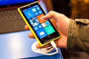 一名男子在2013年10月的倫敦應(yīng)用世界展覽會上檢查了運行Windows Phone 8并擁有4100萬像素攝像頭的新諾基亞Lumia 1020。 